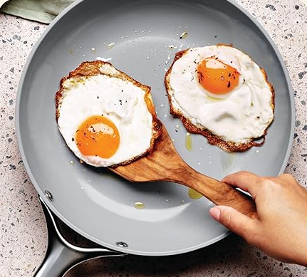 PFAS-free ceramic frying pan cooking eggs on a modern stovetop — non-toxic kitchen essentials